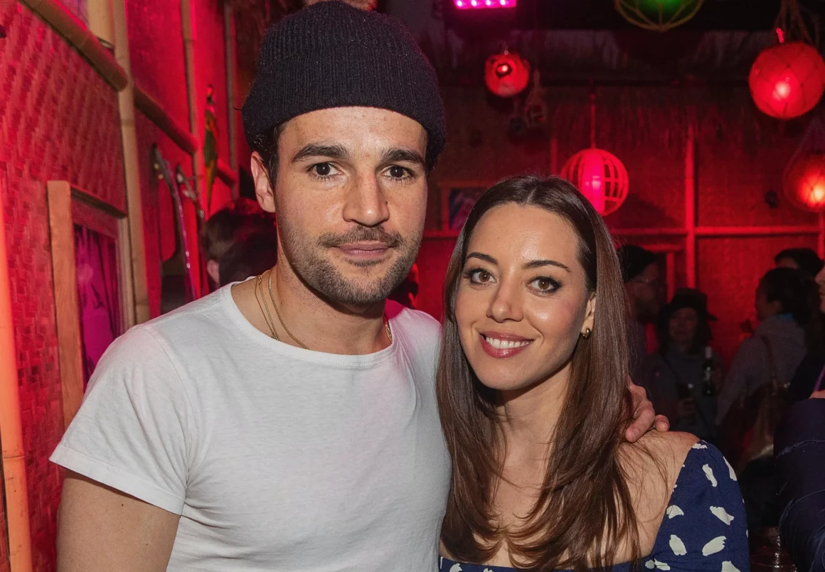 hris Abbott and Aubrey Plaza posing together at a public event.