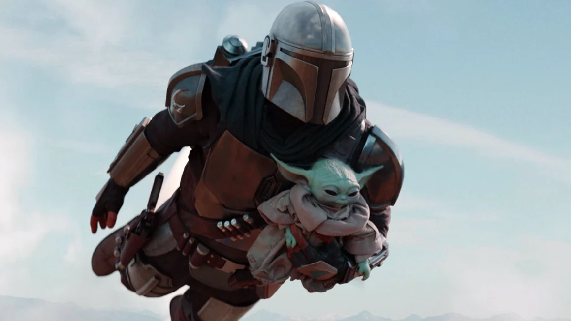 Mandalorian flying with Grogu in his arms during a high-speed aerial scene in a Star Wars setting