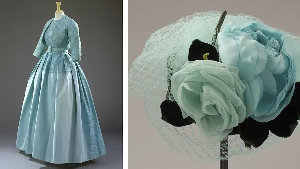 Pale blue formal day dress displayed beside a matching floral hat in the Queen Elizabeth style exhibition at Buckingham Palace.