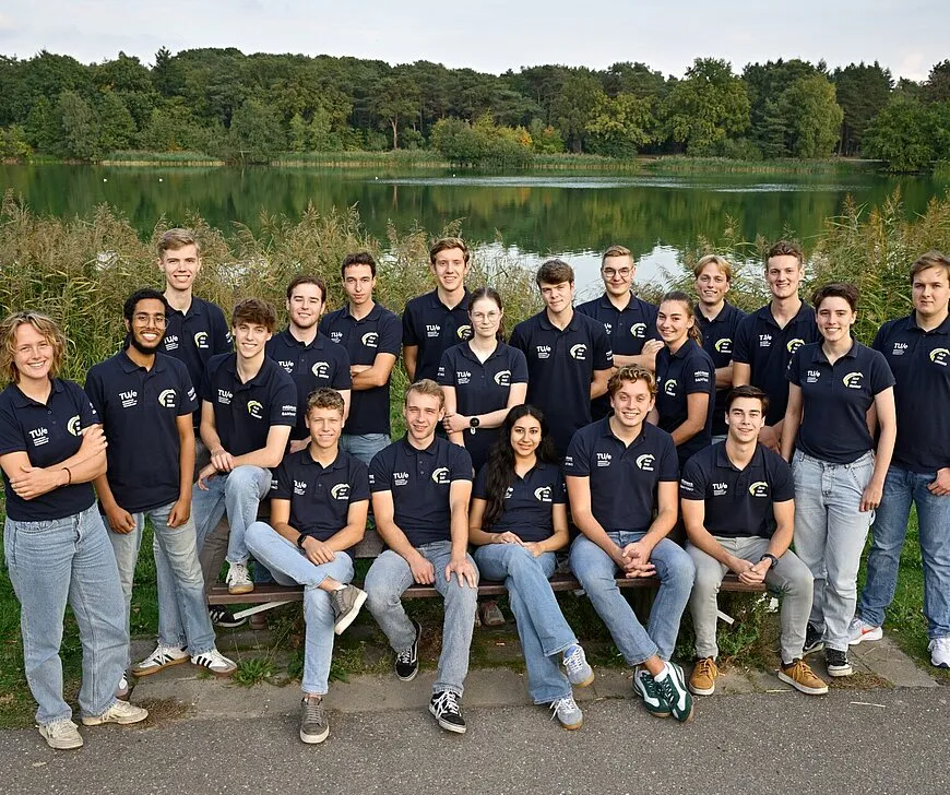 Group photo of Solar Team Eindhoven, the TU/e student team behind the Stella Juva solar ambulance project, posing outdoors by a lakeside.