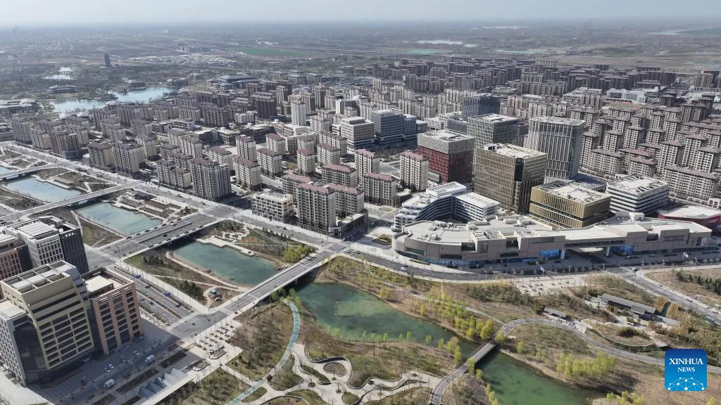 Aerial view of a mixed-use district in Xiong’an New Area, showing mid-rise residential blocks, office buildings, canals, bridges, and landscaped green space in Hebei, China.
