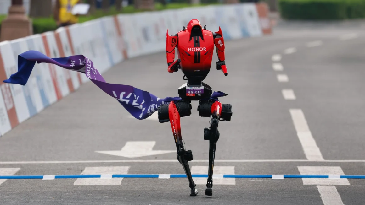 A humanoid robot developed by Honor crosses the finish line during a half marathon race in Beijing