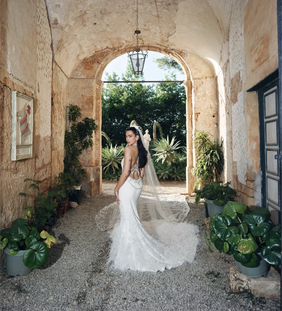 Dua Lipa shows the open back, embroidered veil and feathered train of her Chanel wedding dress in Sicily