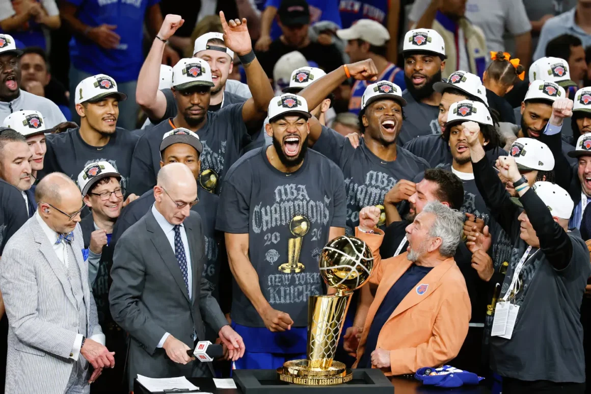 Jalen Brunson celebrates beside the NBA Championship Trophy after leading the New York Knicks to their first title since 1973.